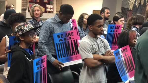 We are all human - students at school board meeting holding posters