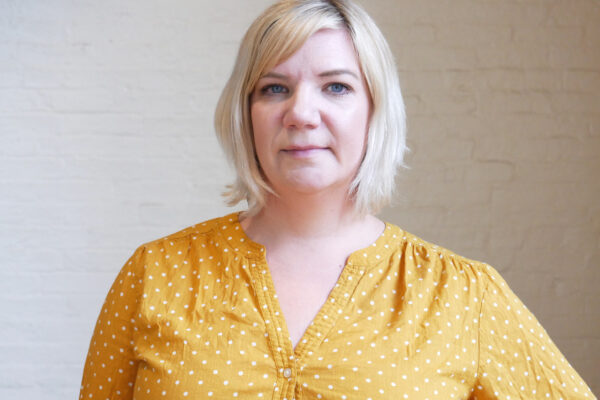 Jenny Trust, white woman with blonde hair and a yellow shirt