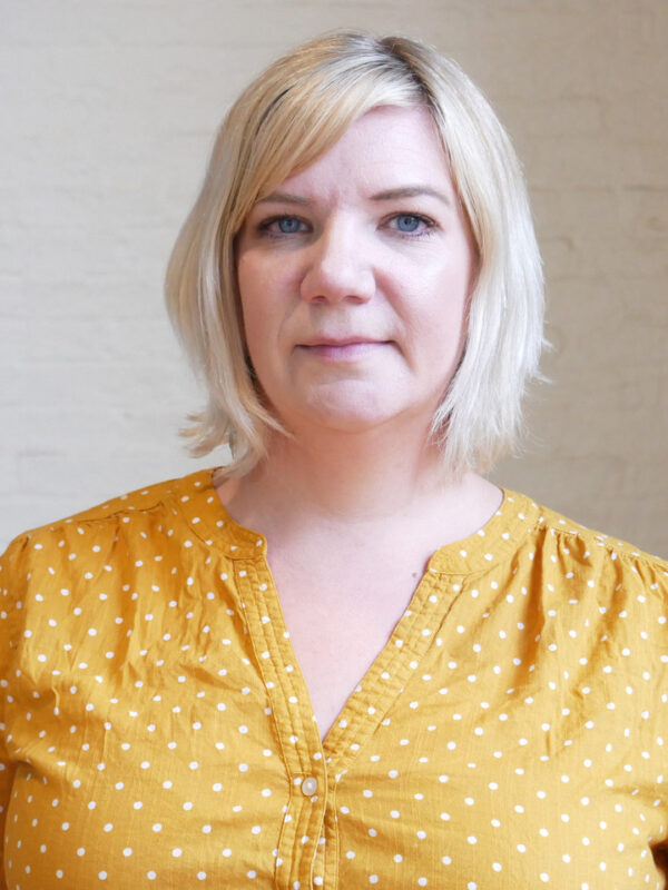 Jenny Trust, white woman with blonde hair and a yellow shirt
