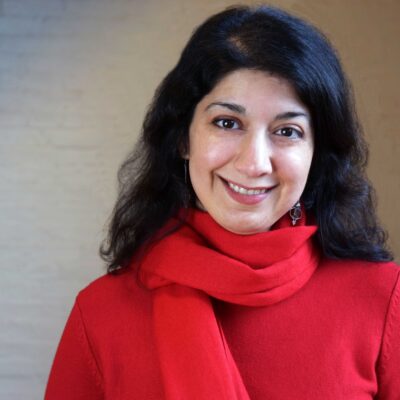 Homayra Ziad, woman with dark, medium-lenth hair, wearing a red shirt and scarf