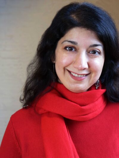 Homayra Ziad, woman with dark, medium-lenth hair, wearing a red shirt and scarf