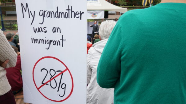Sign at a unity rally that says, "My granmother was an immigrant" and has a 287g inside a red circle with a slash.