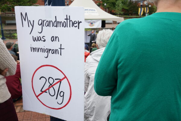 Sign at a unity rally that says, "My granmother was an immigrant" and has a 287g inside a red circle with a slash.