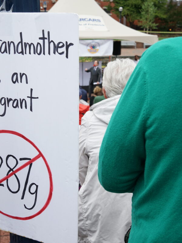 Sign at a unity rally that says, "My granmother was an immigrant" and has a 287g inside a red circle with a slash.