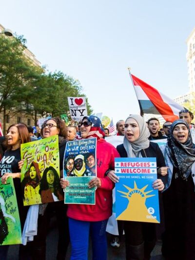 Group of protestors marching with signs supporting Muslim people after Trump's Muslim Ban executive order.