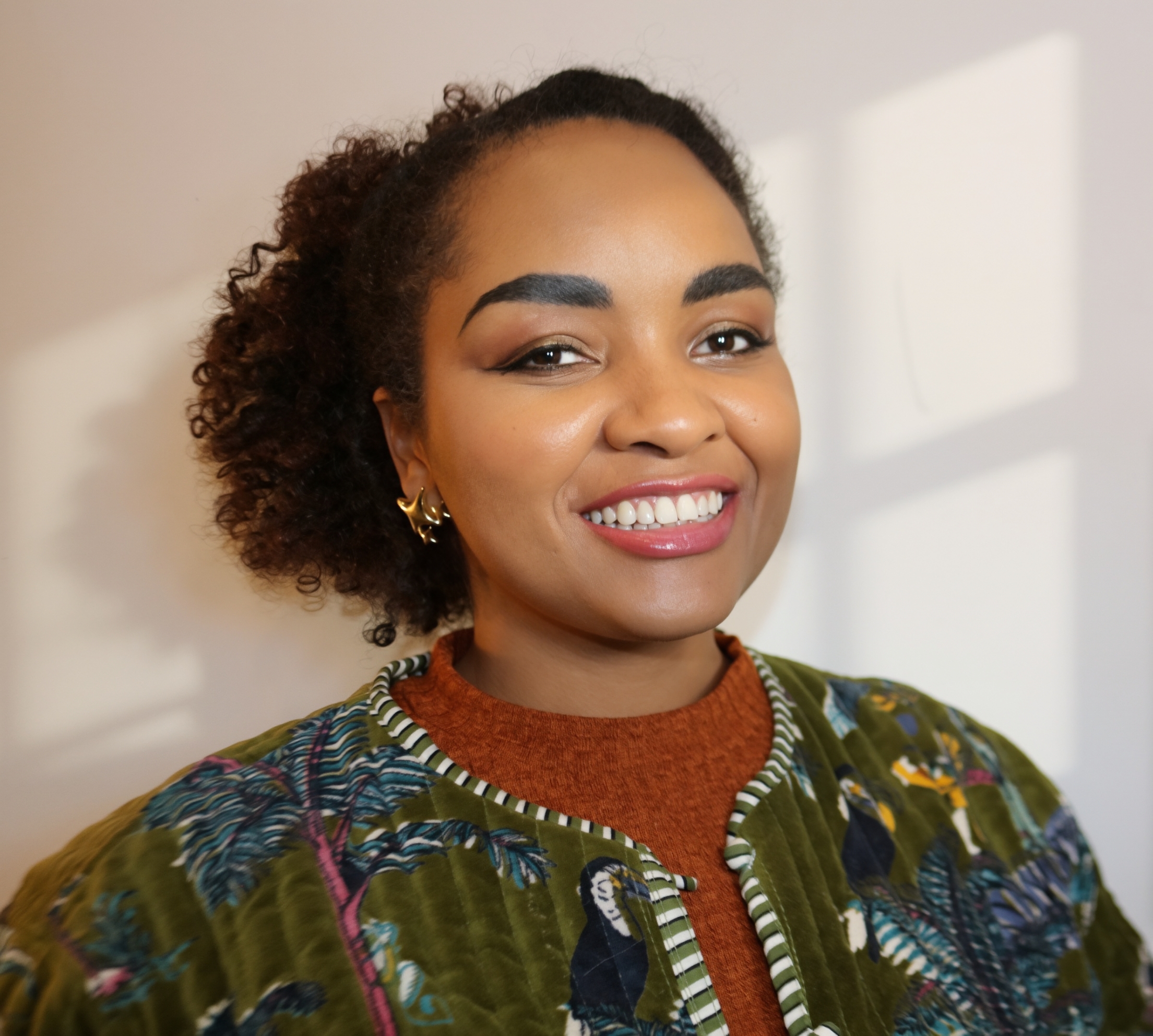 photo of Dara Johnson with curly hair and colorful shirt