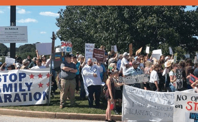 Protest photo with banners and signs saying "Stop Family Separation"