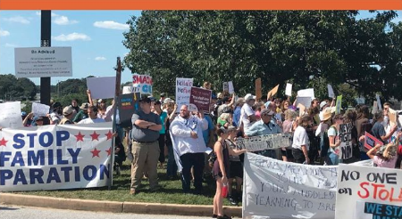 Protest photo with banners and signs saying "Stop Family Separation"