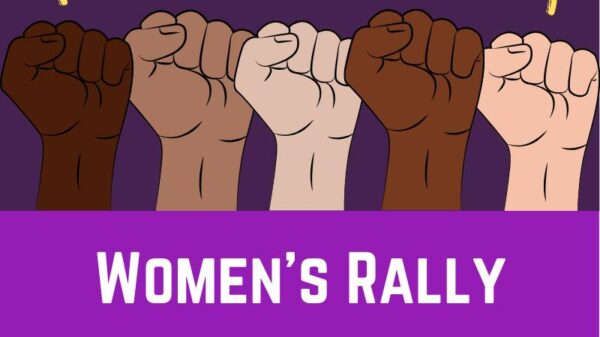 Women's Rally 2020 - purple background with many skin tones fist raised with yellow lightning bolts above the fists