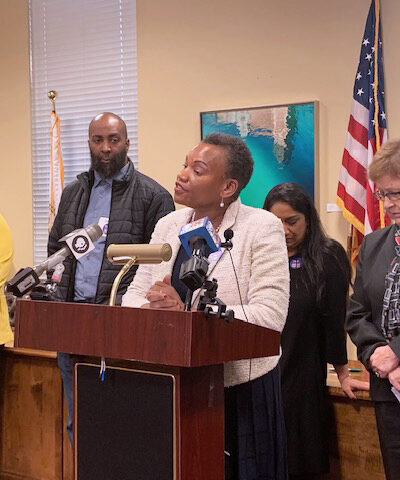 Delegate Pamela Queen spoke out against the currently unjust parole system at a parole reform press conference. She is standing at the podium with several people behind her.