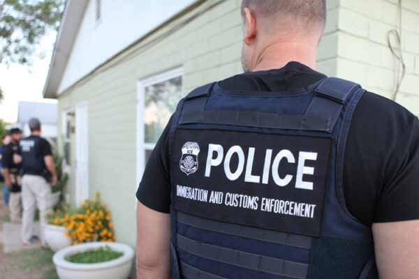 Several ICE officers are at a person's home.
