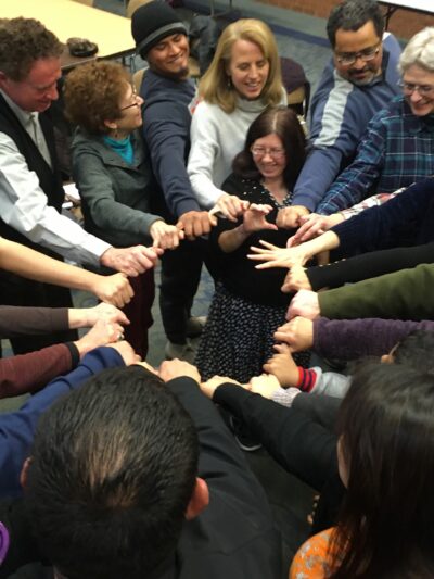 Activists with their hands in a circle.