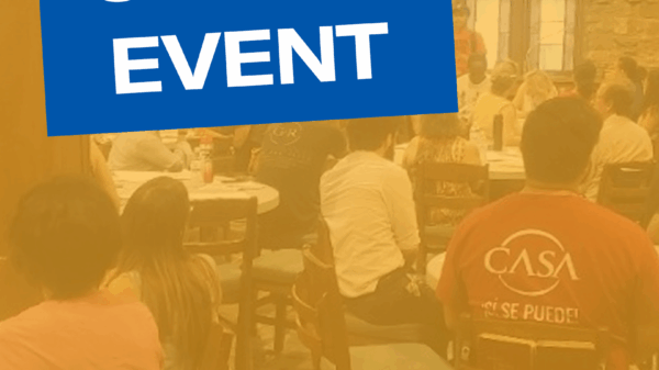 People sitting at tables for a CJSJ town hall meeting