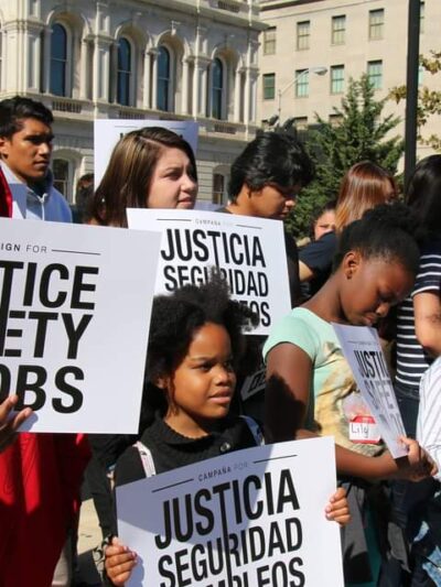 Campaign for Justice, Safety, and Jobs rally - people are at a protest holding signs