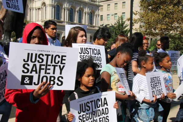 Campaign for Justice, Safety, and Jobs rally - people are at a protest holding signs