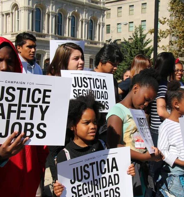 Campaign for Justice, Safety, and Jobs rally - people are at a protest holding signs