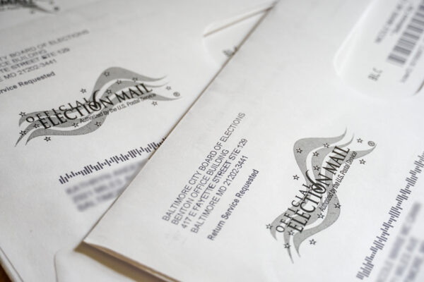 There are two mail letters that say official election mail, with the names and addresses blurred out.