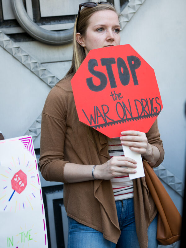 A white person is holding a sign that says