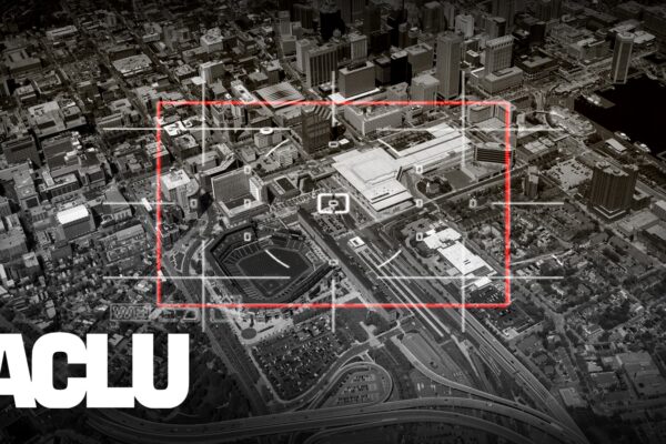 It is a black and white photo with a red target sign pointed at the city of Baltimore below. There is also a white ACLU name on the left of the picture.