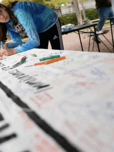 A woman signs a banner at a rally in support of immigrants in Frederick in 2019. (Sarah L. Voisin/The Washington Post)