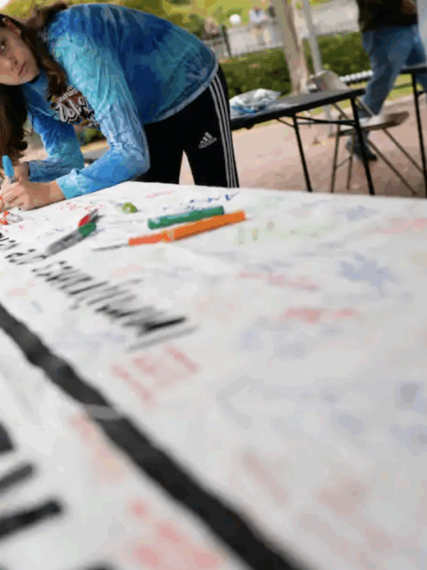 A woman signs a banner at a rally in support of immigrants in Frederick in 2019. (Sarah L. Voisin/The Washington Post)