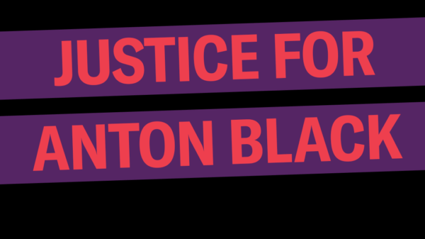 Justice for Anton Black. The background is black, the words are red in a purple rectangle that is slightly tilted up.