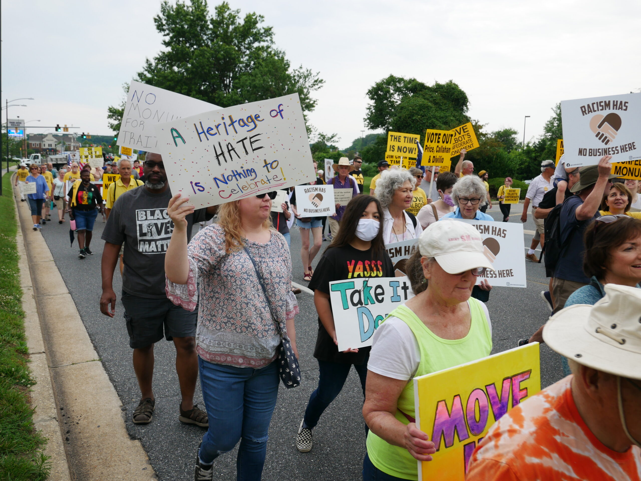 People marching at the Move the Monument rally in Talbot County on Juneteenth. A white person is holding a sign that says