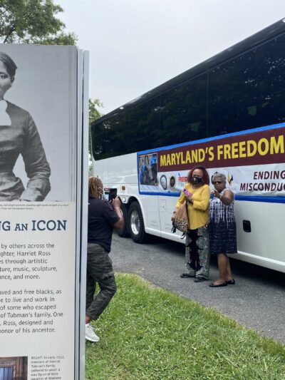 Maryland's Freedom Summer bus beside a sign celebrating the icon Harriet Tubman.