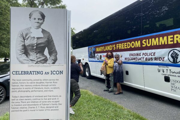 Maryland's Freedom Summer bus beside a sign celebrating the icon Harriet Tubman.