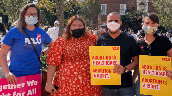 Ellen Hutton, Lorena Diaz, Sergio España, and Amy Cruice are at a rally in Annapolis for abortion rights. They hold protest signs and are standing together looking at the camera.