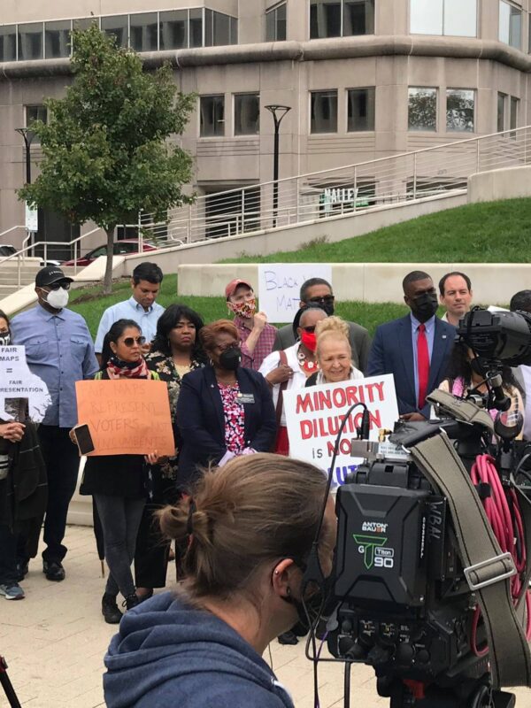 A group of activists stand outside together in Baltimore County at a press conference for the filing of a lawsuit to uphold the Voting Rights Act and create two majority-Black districts.