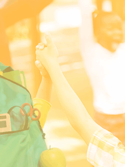 Photo of a teacher and children in a circle holding hands with happy expressions. The photo has a yellow and white gradient overlay. There's a backpack cutout in the bottom left.