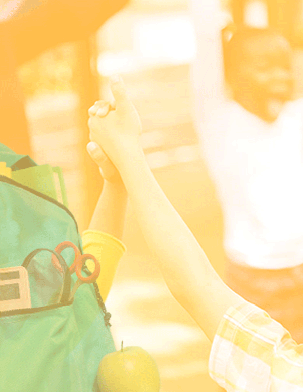 Photo of a teacher and children in a circle holding hands with happy expressions. The photo has a yellow and white gradient overlay. There's a backpack cutout in the bottom left.