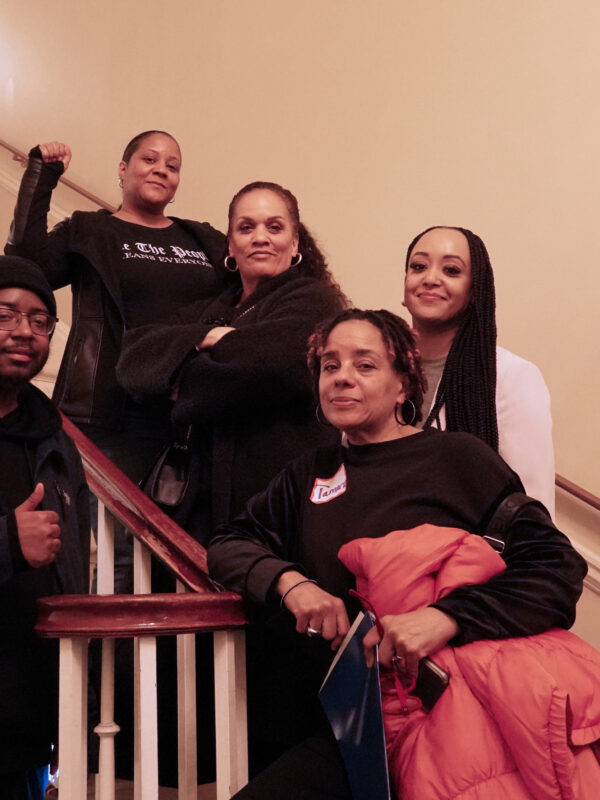 Black activists standing on stairs at the ACLU of Maryland Lobby Day event. One person has their fist raised. Activists are lobbying their legislators at the event for civil rights.
