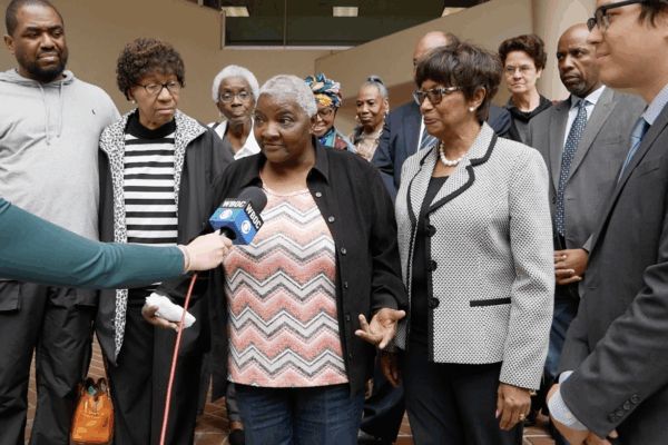 Local Black activists, residents, and Maryland laywers are in a group outside of a Federalsburg courthouse with a reporter holding a microphone up to a Black resident.