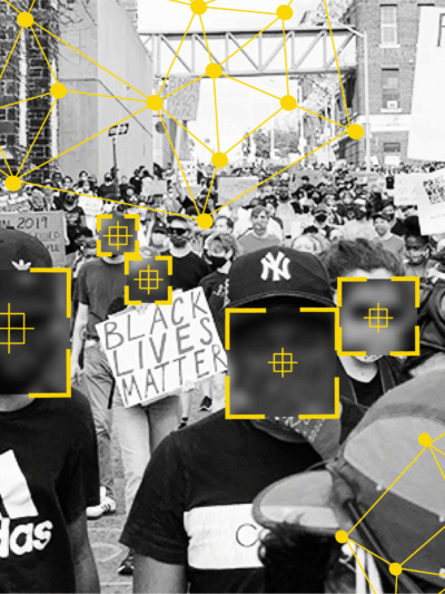 Black and white photo of people at a protest. There are overlays over people's faces that signify facial recognition technology identifying people.