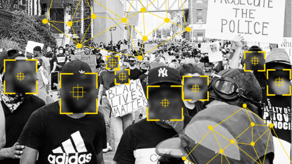 Black and white photo of people at a protest. There are overlays over people's faces that signify facial recognition technology identifying people.
