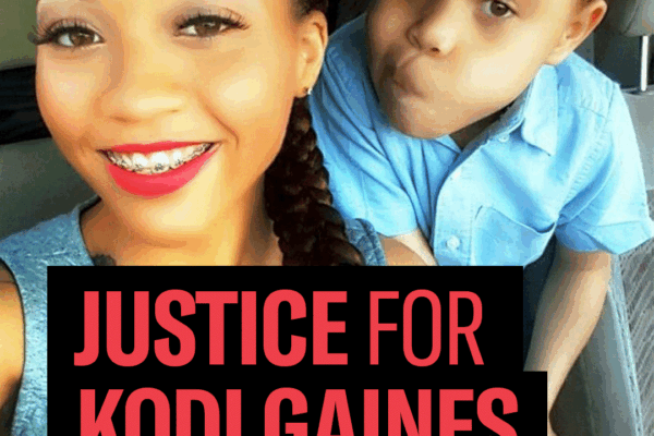 Justice for Kodi Gaines. Korryn Gaines, a Black woman with her hair in a braid, smiling, and wearing red lipstick, and her son Kodi, who is wearing a red hat and blue shirt, are taking a selfie and looking at the camera.