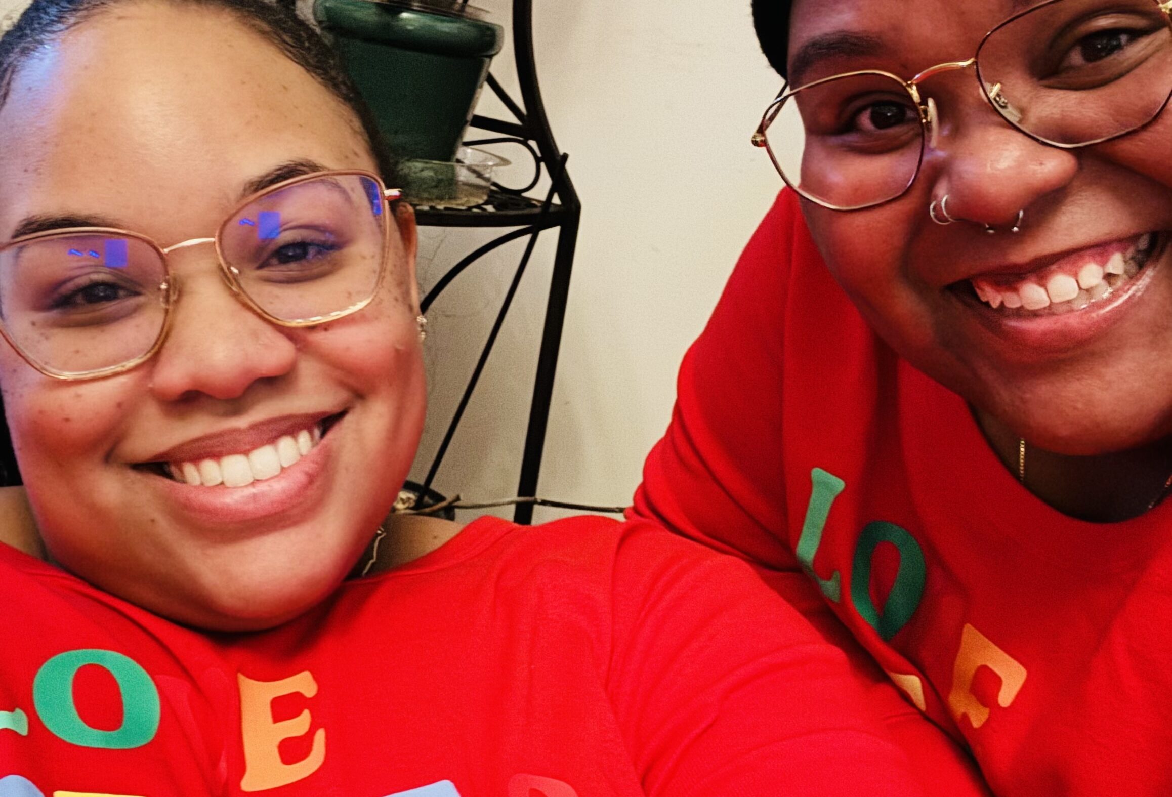 Antoinette and Alicia celebrating with family on Christmas 2023. They are wearing matching red holiday outfits.They were celebrating with family on Christmas 2023.