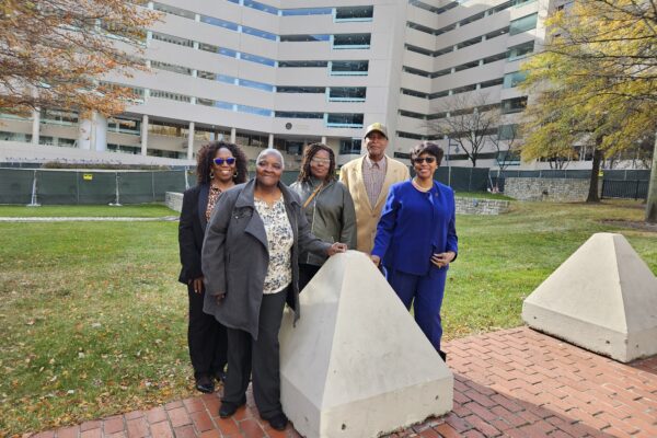 A group of Black residents and plaintiffs in the Federalsburg voting rights case stand together in front of a court building where their case was heard.