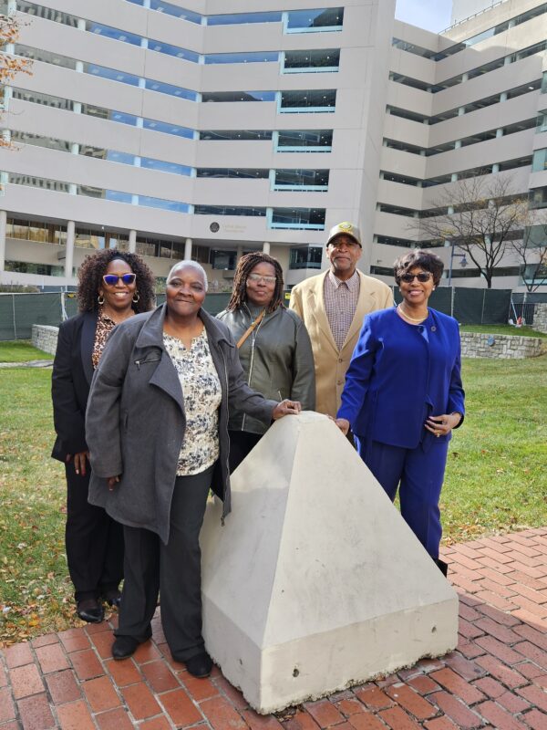 A group of Black residents and plaintiffs in the Federalsburg voting rights case stand together in front of a court building where their case was heard.