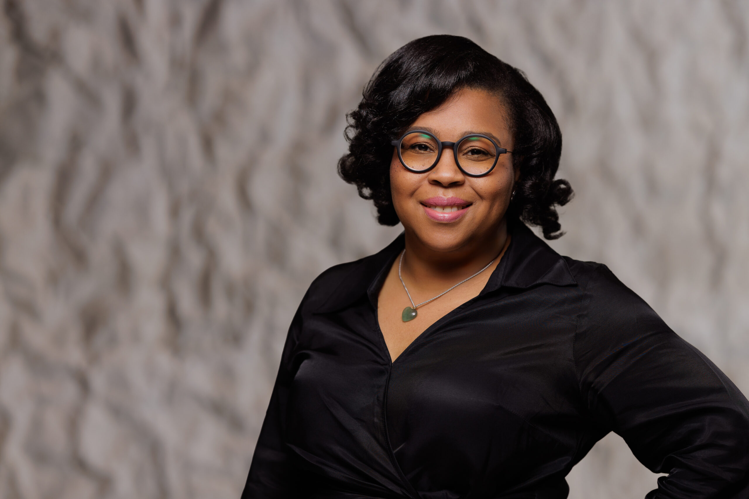 Stefany in a black shirt and black glasses