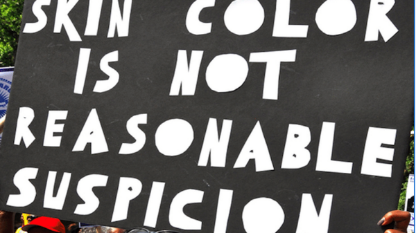 Black and white sign that says" Skin color is not..."