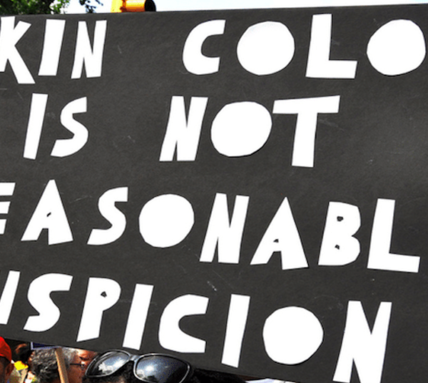 Black and white sign that says" Skin color is not..."