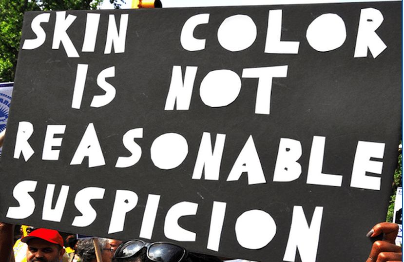 Black and white sign that says" Skin color is not..."