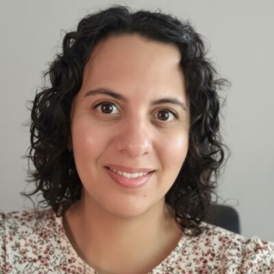 Tatiana has dark hair and a spotted shirt