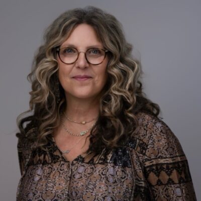 Wendy in dark glasses and a brown shirt