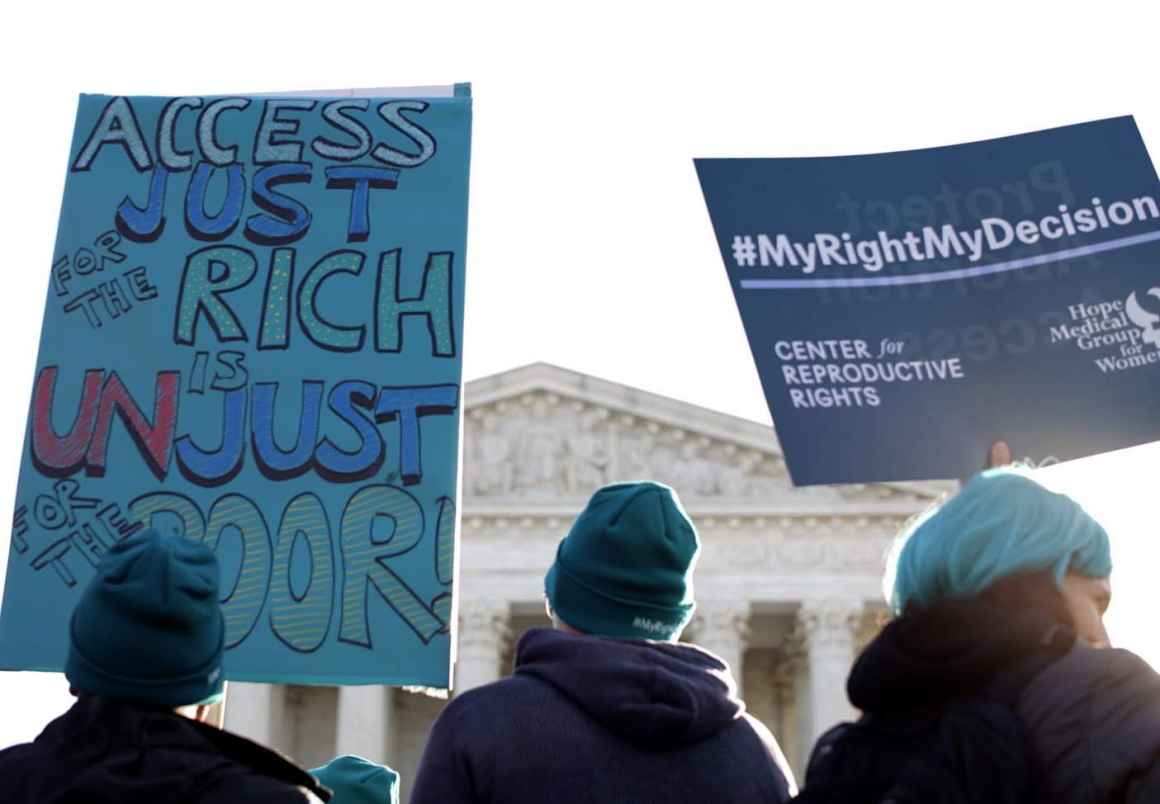 At an abortion rights rally in front of the Supreme Court, protesters hold a sign that says Access Just for the Rich is Unuust for the poor.