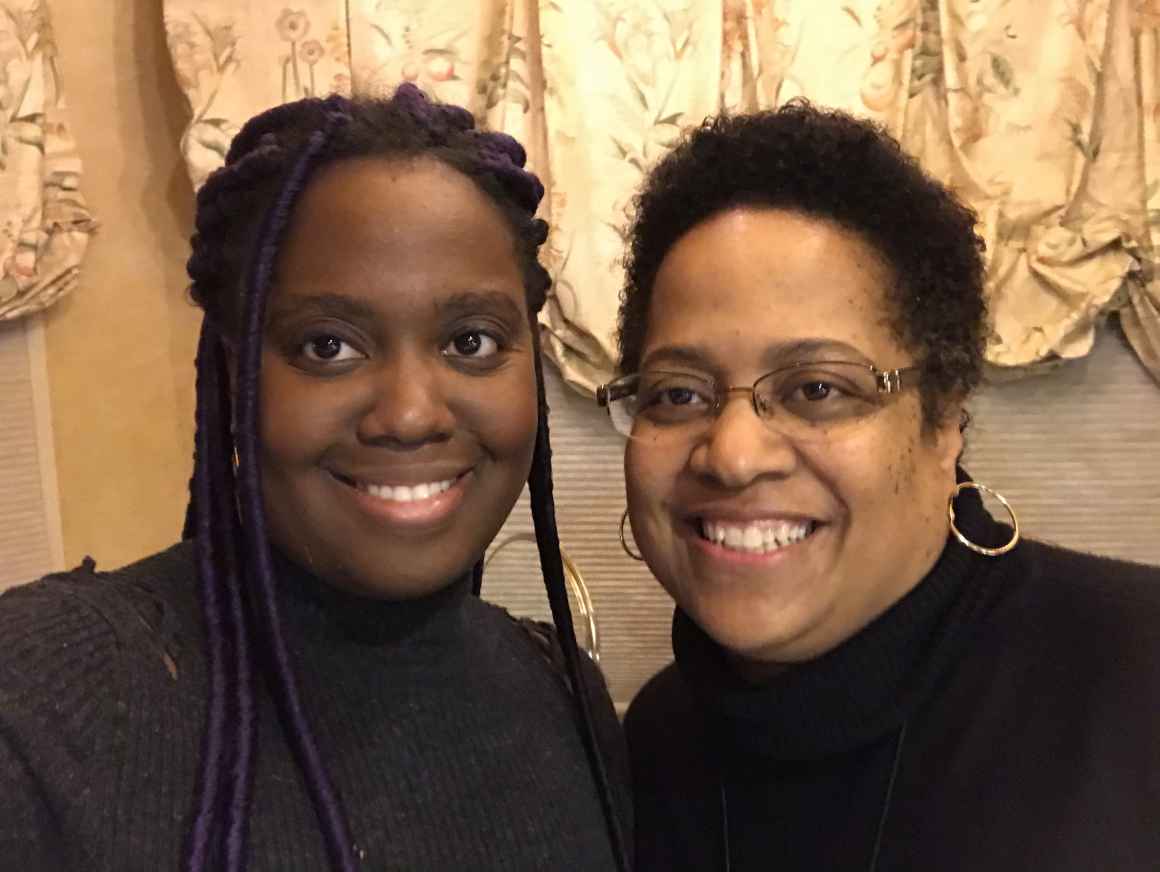 Amber Taylor (left) and her mom (right) take a selfie. They both have natural hair styles. Amber is wearing long faux locs.