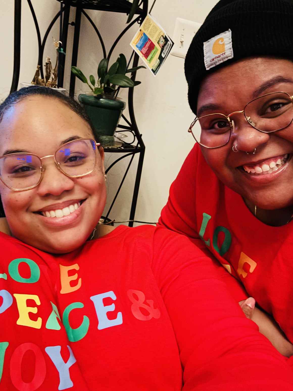 Antoinette and Alicia celebrating with family on Christmas 2023. They are wearing matching red holiday outfits.They were celebrating with family on Christmas 2023.